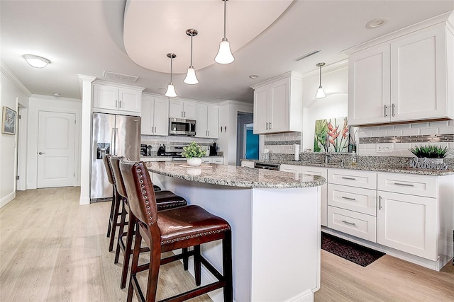 kitchen featuring light wood-style floors, appliances with stainless steel finishes, and white cabinets