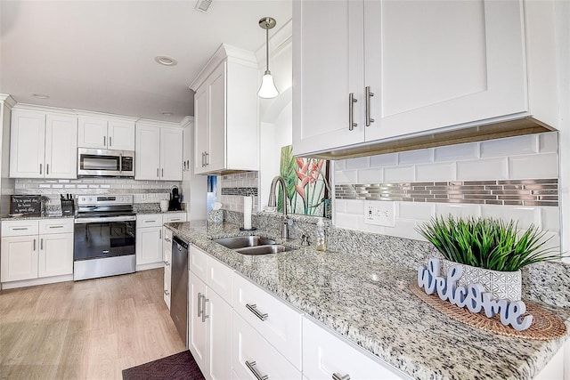 kitchen with white cabinets, stainless steel appliances, and a sink