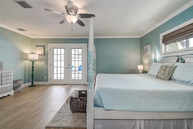 bedroom featuring access to exterior, french doors, visible vents, ornamental molding, and wood finished floors