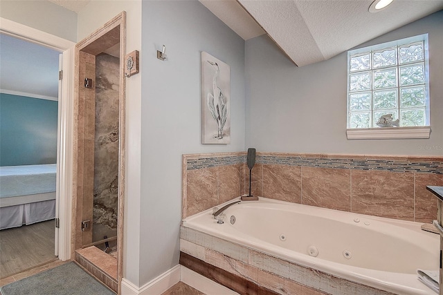 full bath with a textured ceiling, connected bathroom, vaulted ceiling, a jetted tub, and a stall shower