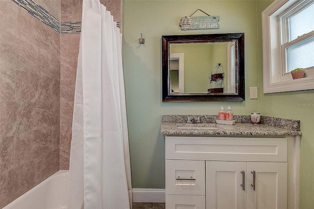 full bath with shower / tub combo with curtain, vanity, and baseboards