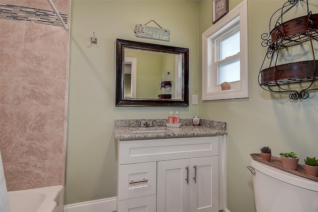 bathroom with baseboards, vanity, and toilet