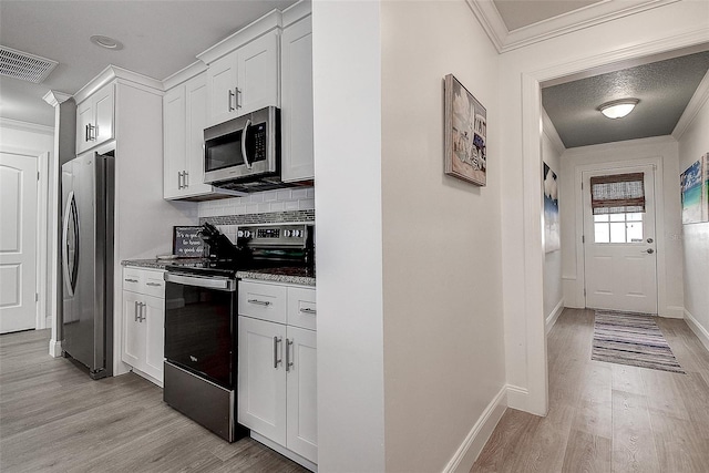 kitchen featuring stainless steel appliances, light wood-style flooring, visible vents, and crown molding