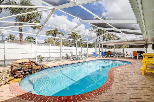 view of pool with a patio area, a fenced backyard, a fenced in pool, and a lanai