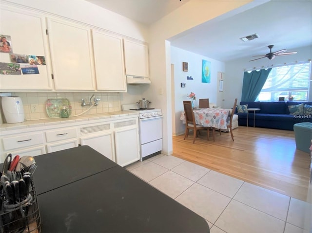 kitchen with visible vents, tile countertops, light tile patterned floors, electric stove, and white cabinets