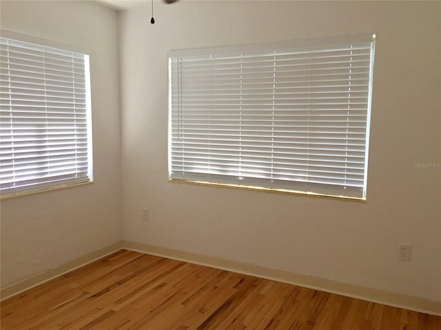 empty room featuring baseboards and wood-type flooring