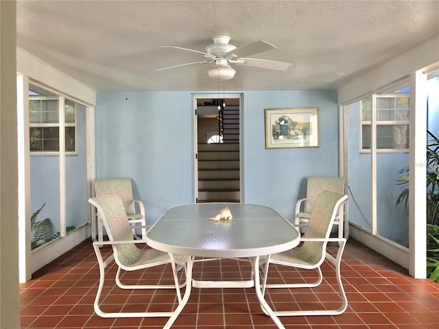 tiled dining space featuring stairs and a ceiling fan