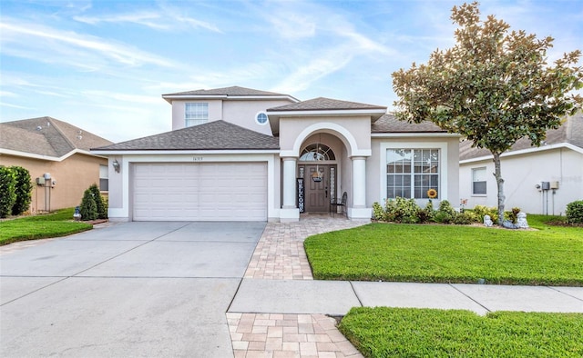 view of front of home featuring a front yard, concrete driveway, an attached garage, and stucco siding