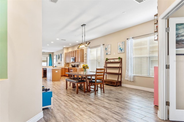 dining space with light wood finished floors, recessed lighting, and baseboards