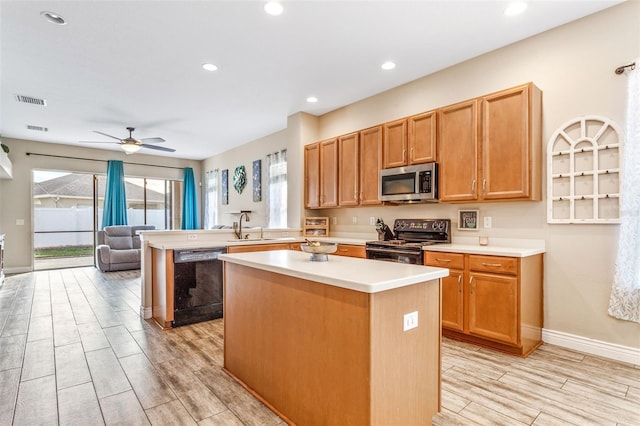 kitchen featuring black dishwasher, electric stove, stainless steel microwave, wood tiled floor, and a kitchen island