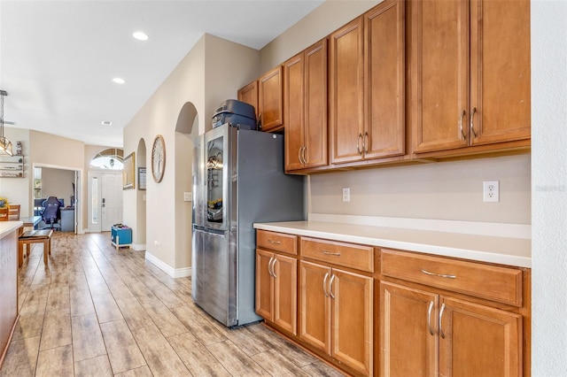 kitchen featuring light countertops, smart refrigerator, and brown cabinets