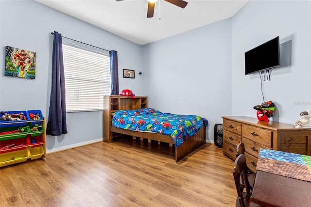 bedroom with light wood-style floors, baseboards, and a ceiling fan