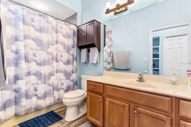 bathroom with toilet, curtained shower, and vanity