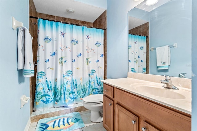 bathroom featuring vanity, tiled shower, tile patterned flooring, and toilet