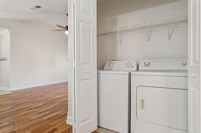 laundry area featuring a ceiling fan, visible vents, light wood finished floors, laundry area, and washing machine and dryer