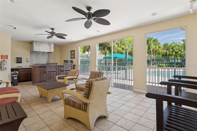 living room featuring light tile patterned flooring, a ceiling fan, and baseboards