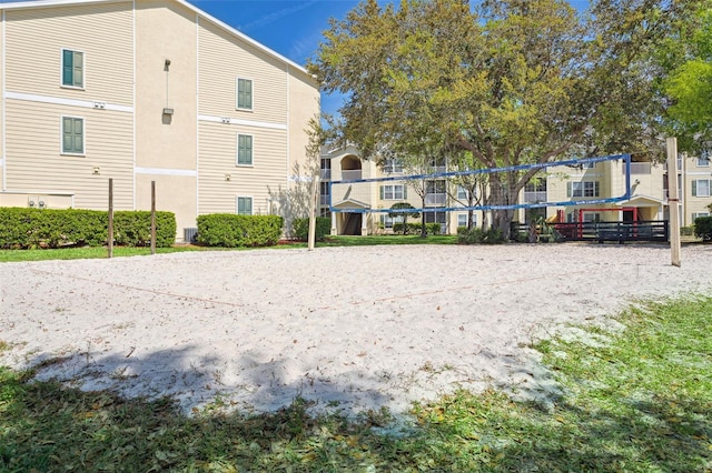 rear view of property featuring volleyball court