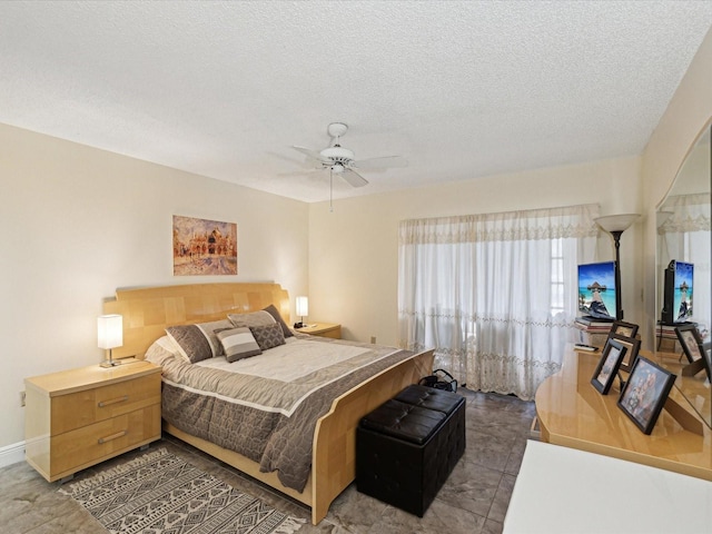 bedroom featuring baseboards, a ceiling fan, and a textured ceiling