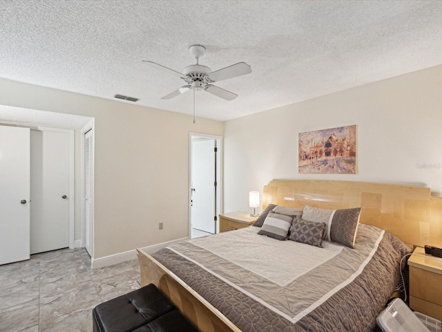 bedroom featuring baseboards, visible vents, ceiling fan, and a textured ceiling