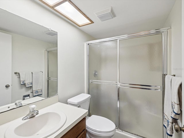 bathroom with visible vents, vanity, toilet, and an enclosed shower