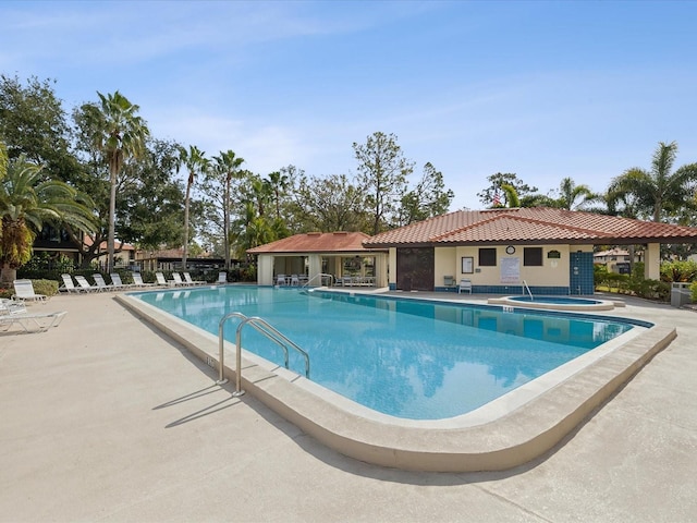 community pool with a community hot tub and a patio