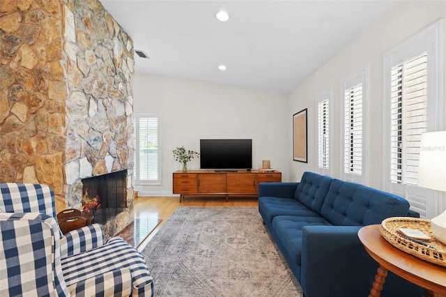 living area with a fireplace, wood finished floors, visible vents, and recessed lighting