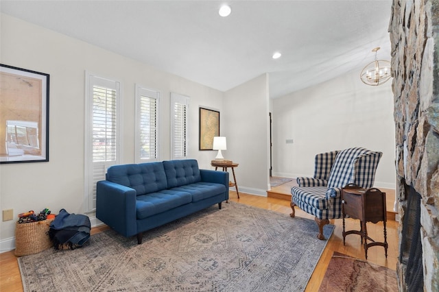 living area with an inviting chandelier, wood finished floors, and baseboards