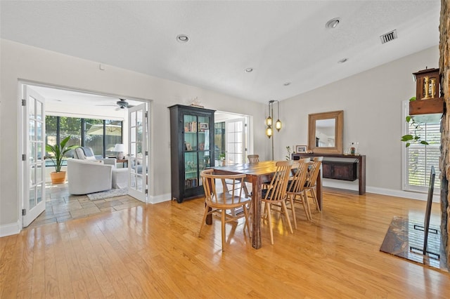 dining space featuring lofted ceiling, light wood finished floors, baseboards, and visible vents