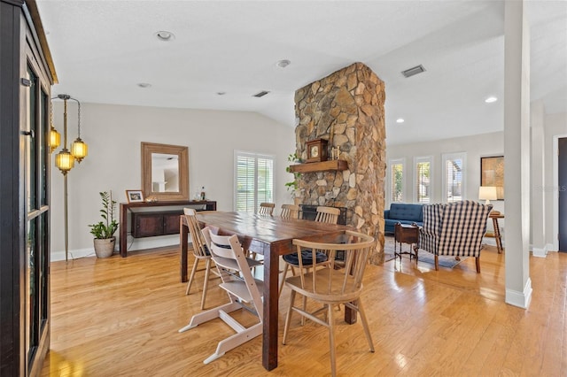 dining area featuring lofted ceiling, light wood-type flooring, and visible vents