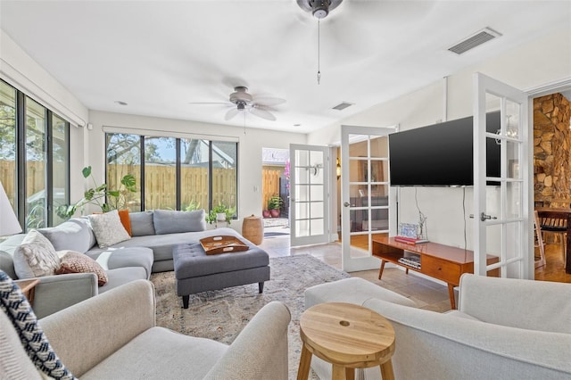 living room with french doors, visible vents, and a ceiling fan