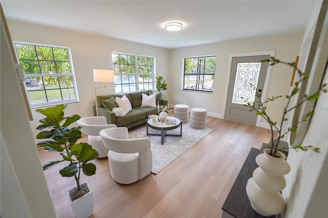 living area with light wood-type flooring and baseboards