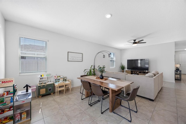 dining area featuring light tile patterned floors, ceiling fan, and baseboards