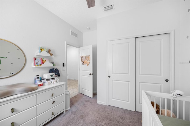 bedroom featuring a nursery area, visible vents, a sink, and light colored carpet