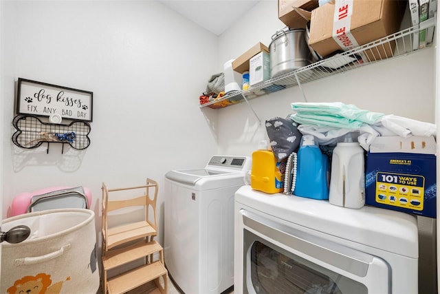 clothes washing area featuring laundry area and washer and clothes dryer