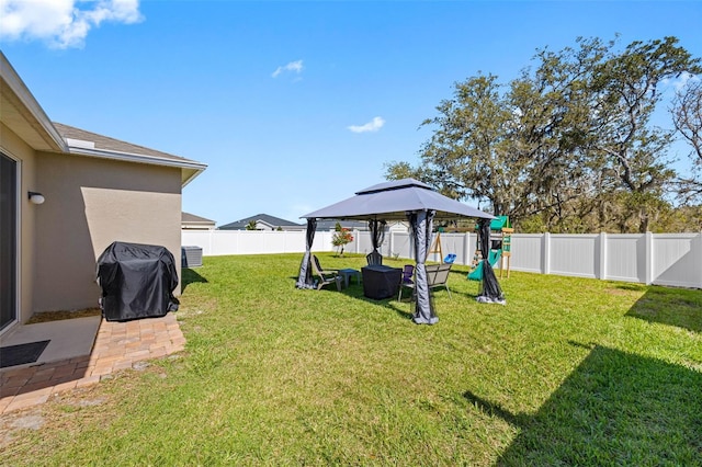 view of yard with a patio area, a fenced backyard, a playground, and a gazebo