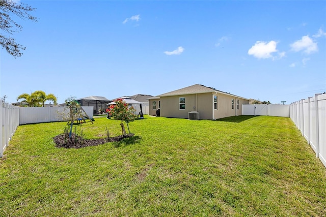 view of yard with central AC and a fenced backyard