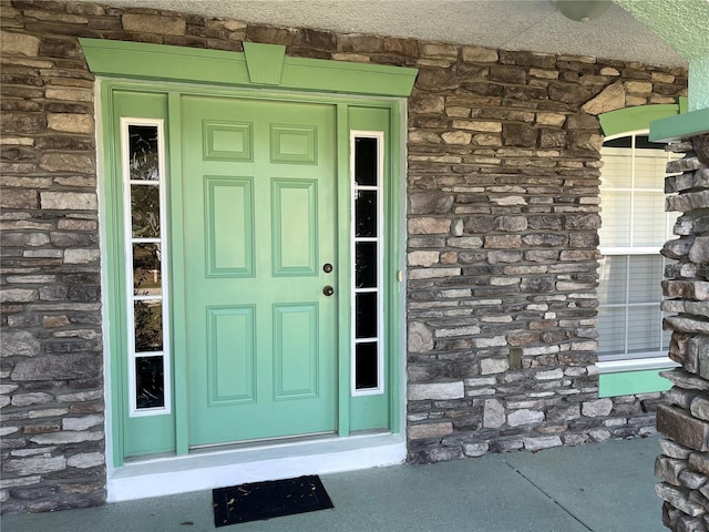 entrance to property featuring stone siding