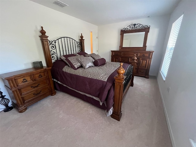 bedroom with light carpet, visible vents, and baseboards