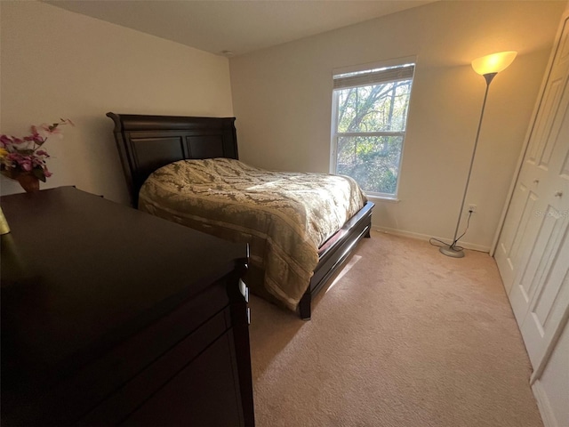 bedroom featuring light colored carpet and baseboards