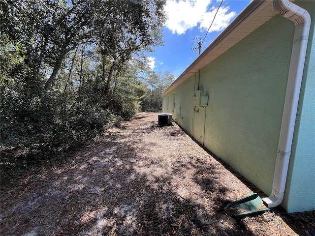 view of home's exterior with cooling unit and stucco siding