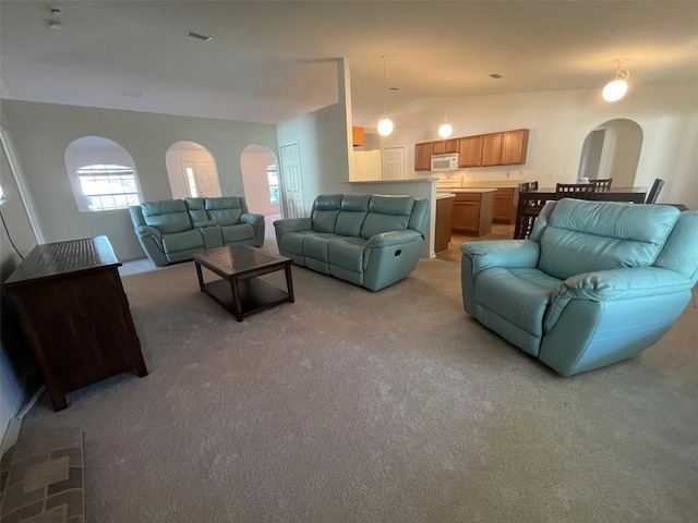 living room with arched walkways, lofted ceiling, and light colored carpet