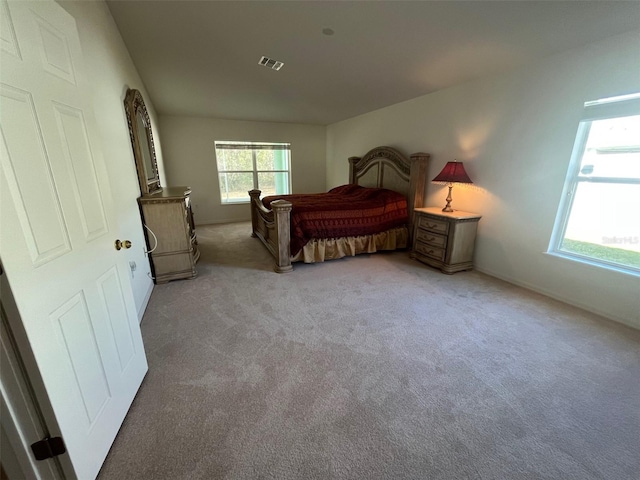 bedroom featuring visible vents and light colored carpet