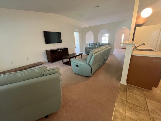 living area featuring arched walkways, light colored carpet, and lofted ceiling