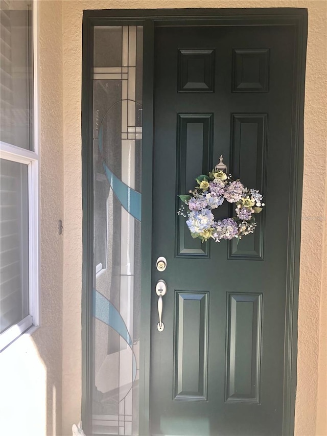 view of exterior entry with stucco siding