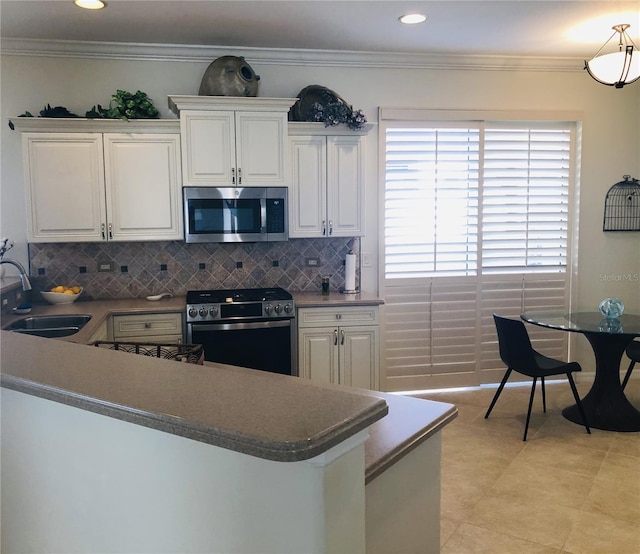 kitchen with crown molding, white cabinetry, stainless steel appliances, and a sink