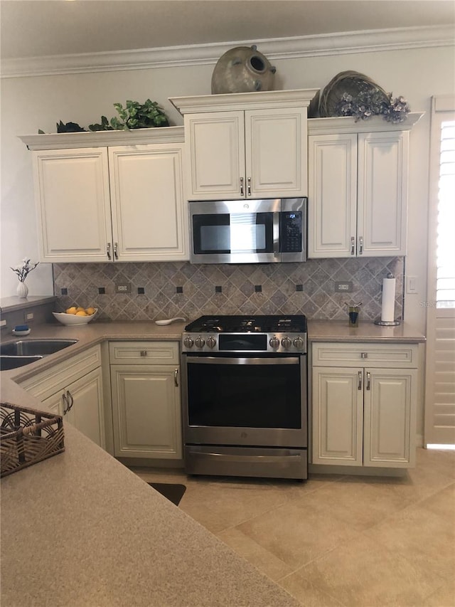 kitchen featuring appliances with stainless steel finishes, backsplash, a sink, and ornamental molding