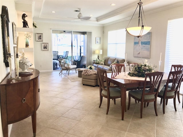 dining space with ornamental molding, plenty of natural light, and a raised ceiling