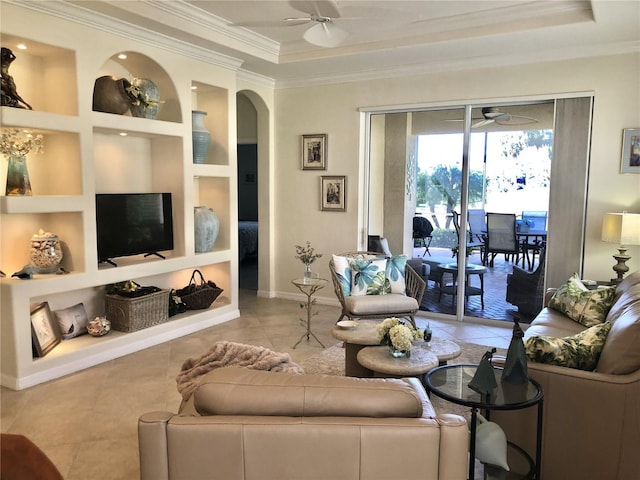 tiled living area featuring built in features, arched walkways, baseboards, ceiling fan, and ornamental molding