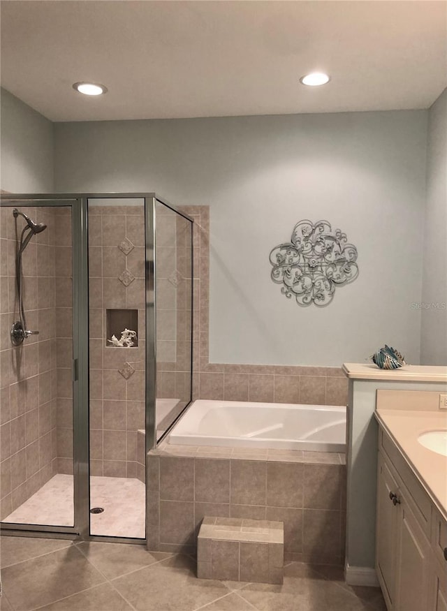 full bath featuring a stall shower, tile patterned flooring, a bath, and vanity