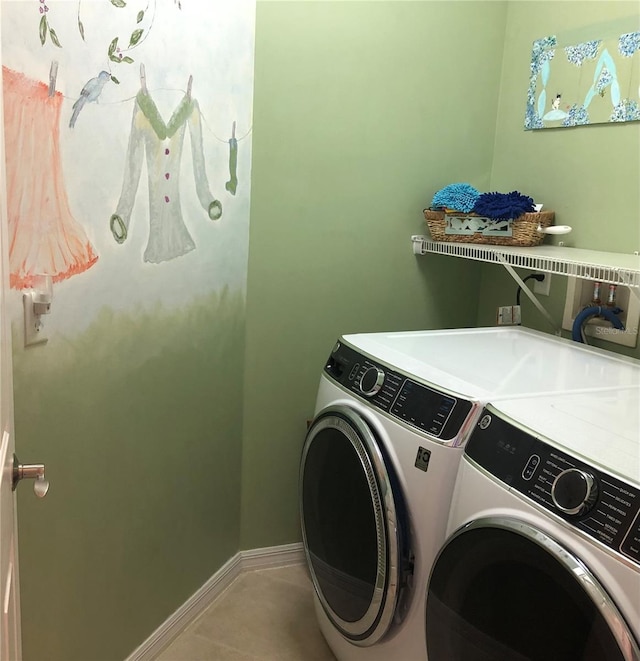 laundry area with washer and dryer, laundry area, baseboards, and tile patterned floors